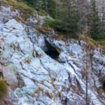 a rocky cliff with a hole in the middle of it